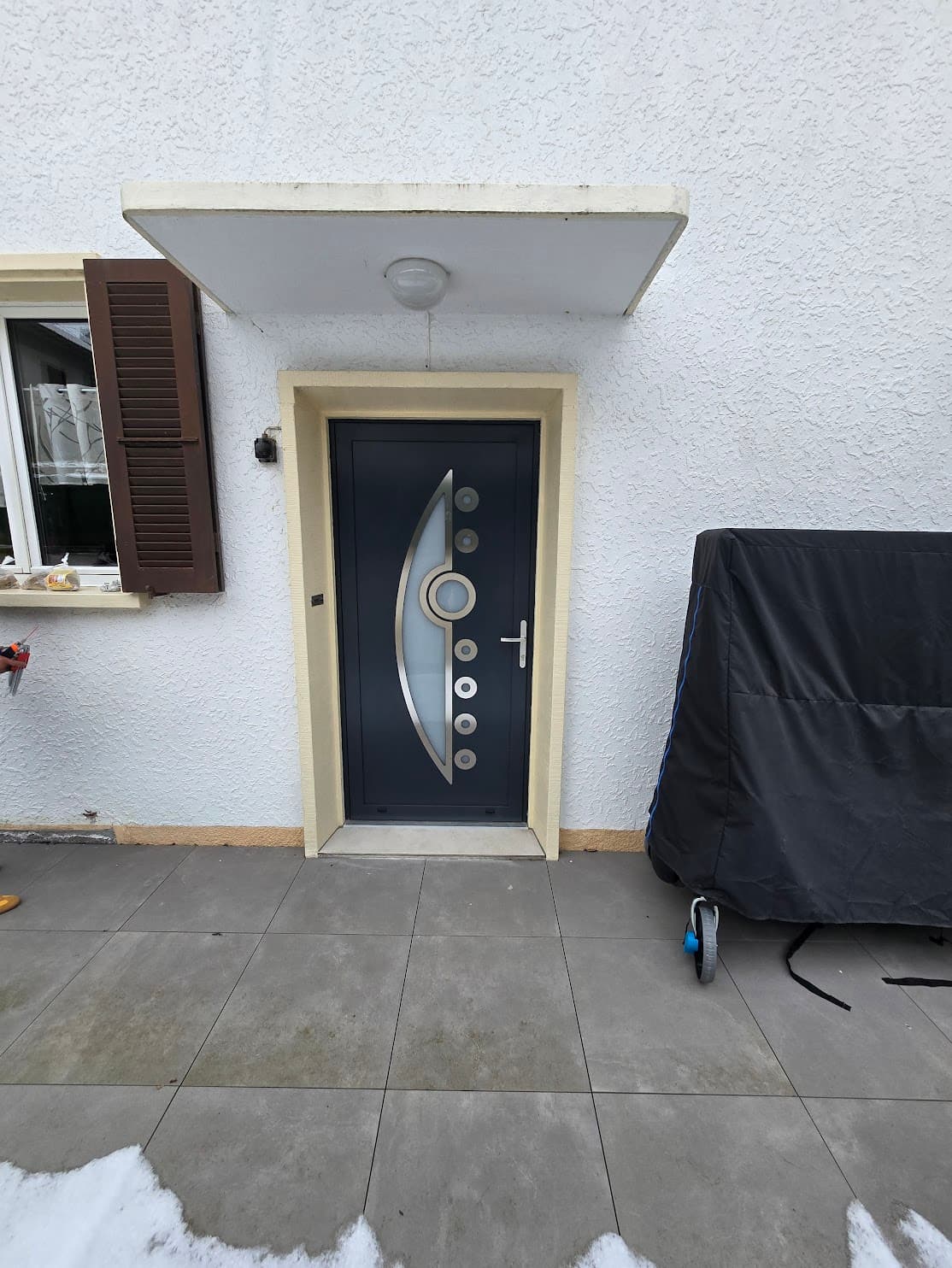 Porte d'entrée noire moderne installée sur une façade contemporaine