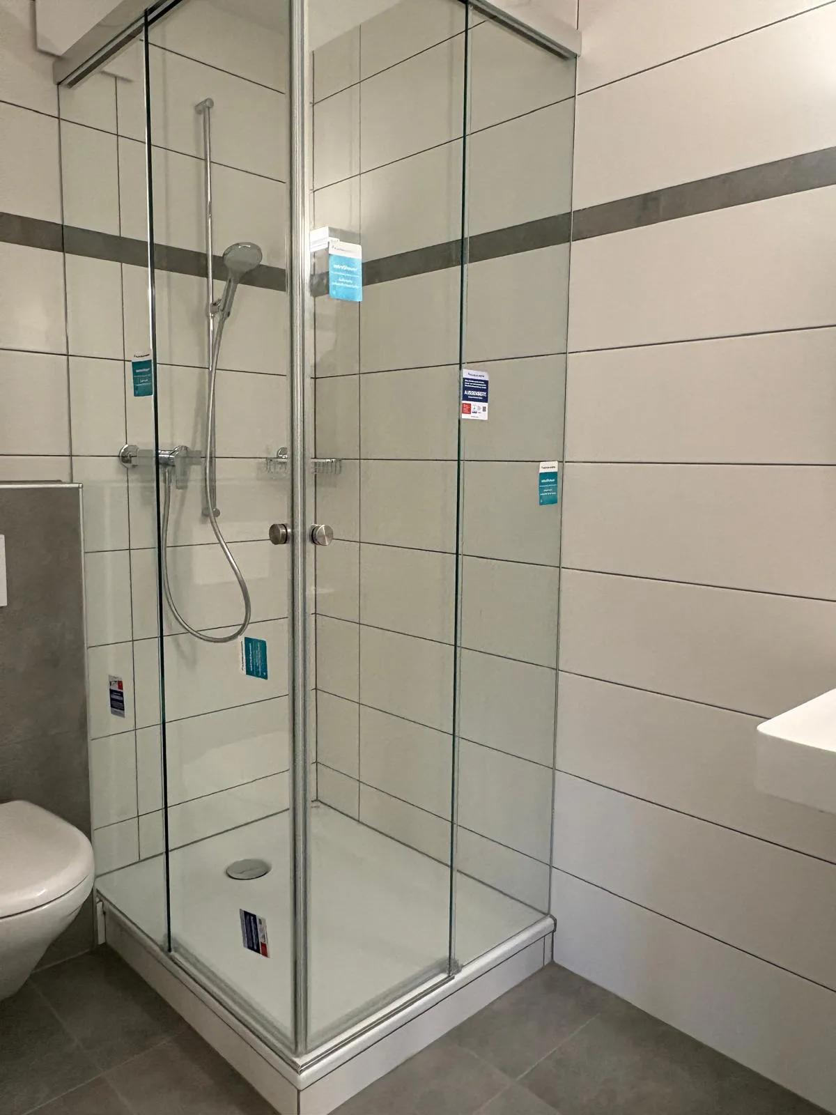 Clear shower enclosure with glass door in a tiled bathroom