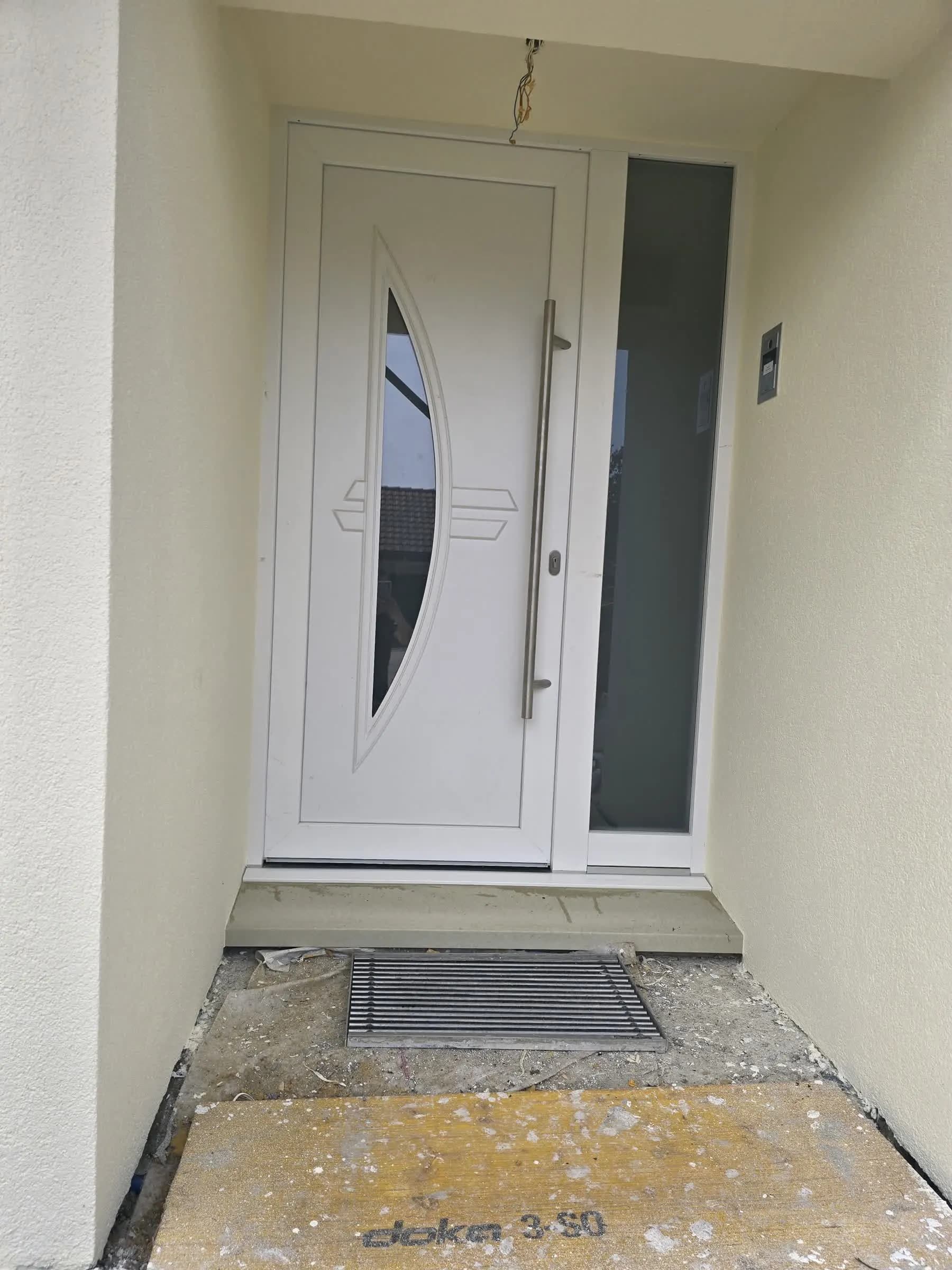 White entrance door with glazed transom during installation