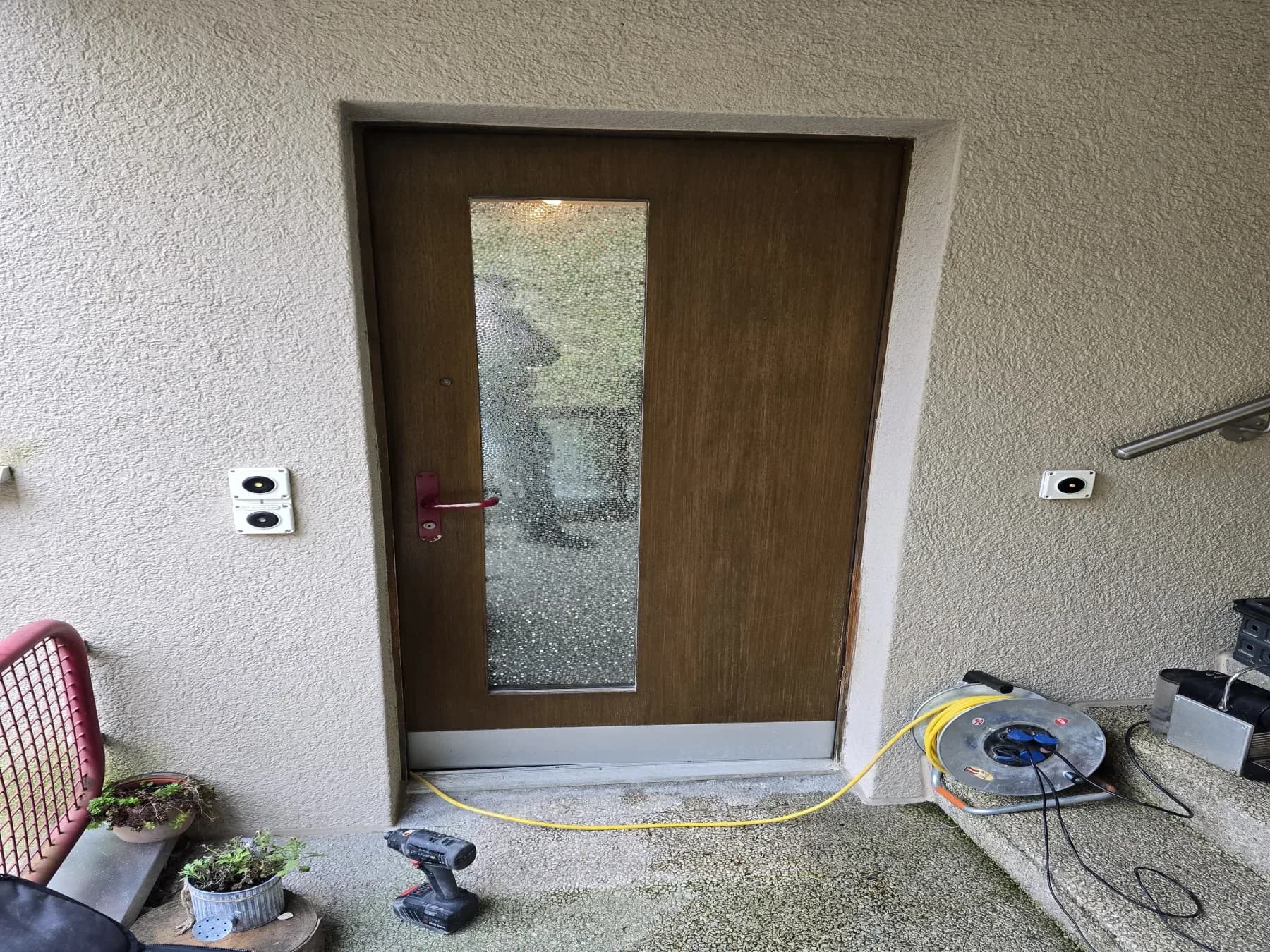 Old brown entrance door with a vertical textured-glass panel
