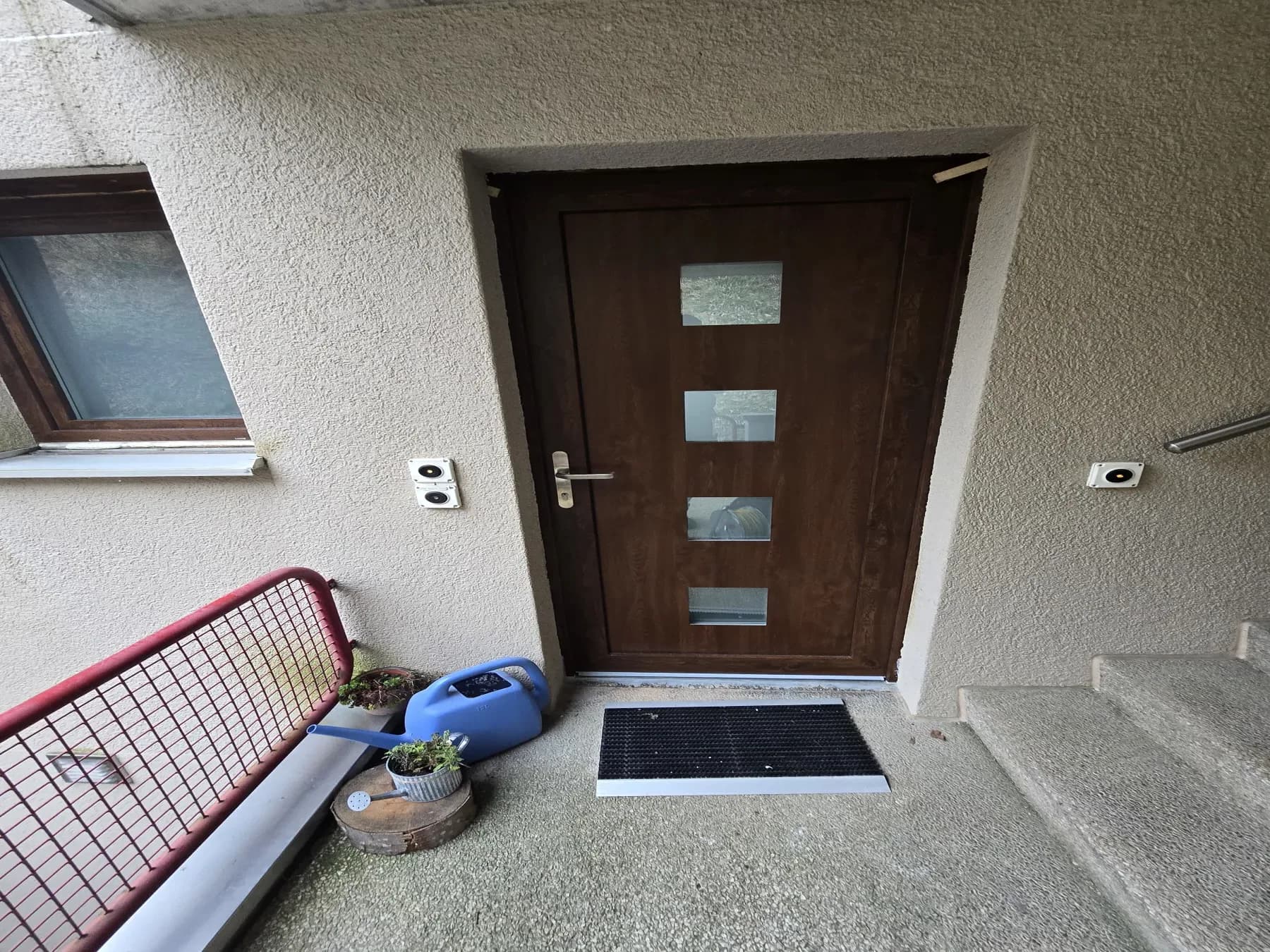 Brown entrance door with four square glazed inserts after replacement