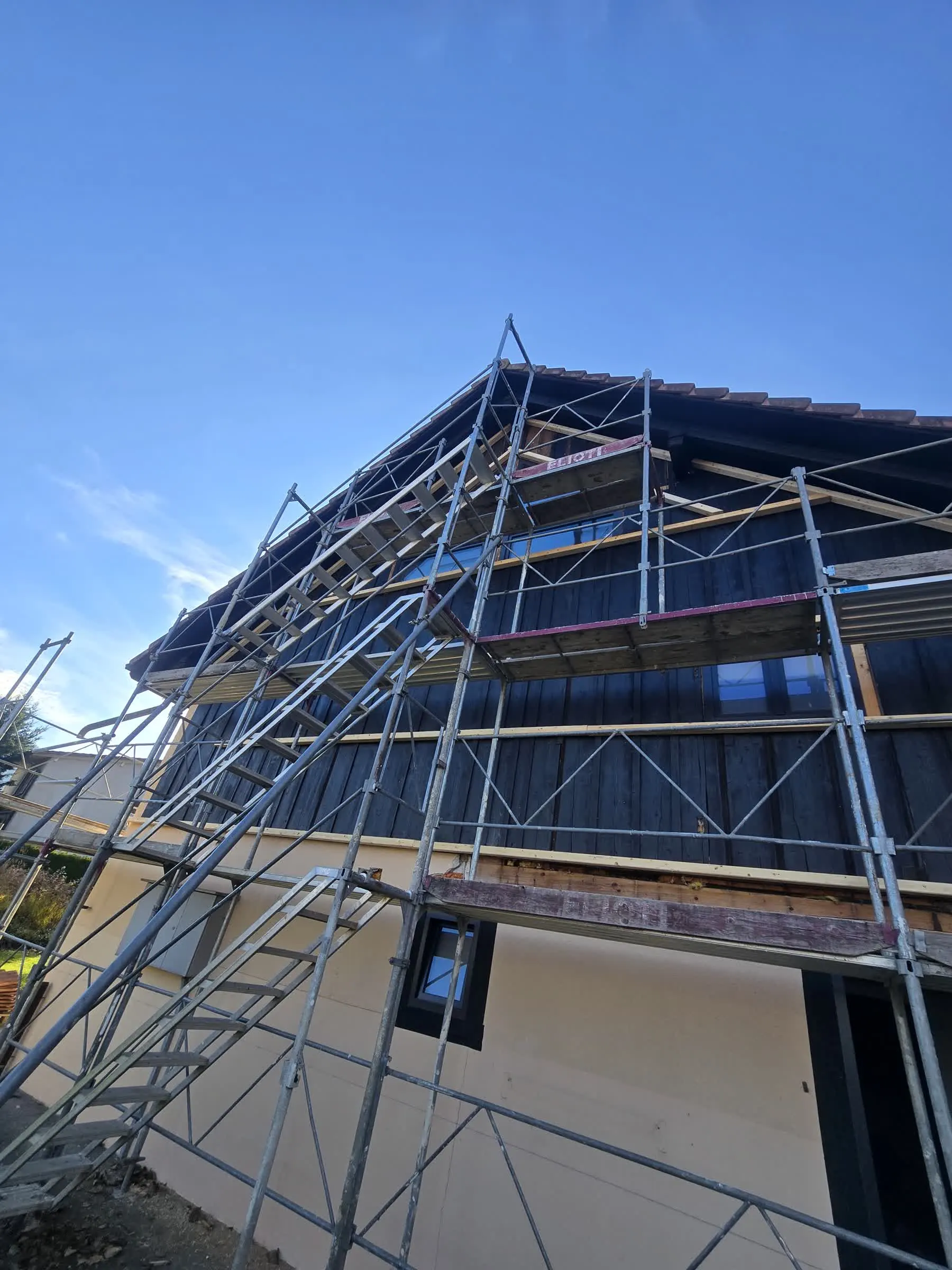 Fassade in Renovation mit neuen Fenstern und Gerüst